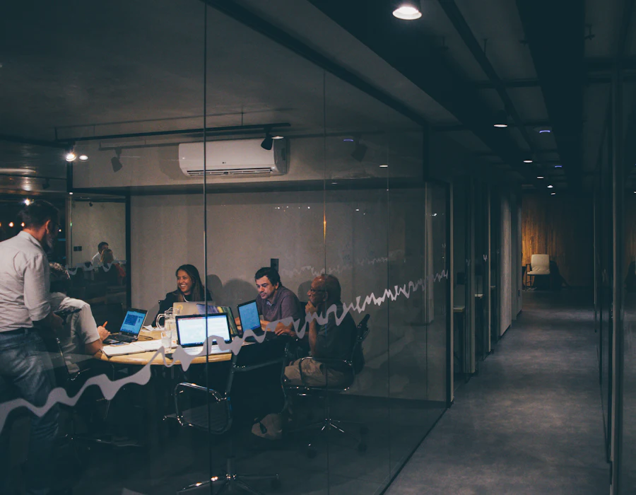 A team working late in a glass-walled meeting room